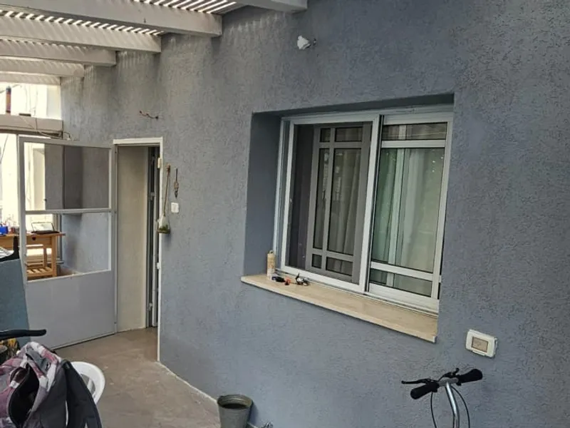תיקוני טיח, החלקה וצביעה של קיר חיצוני במרפסת מקורה — אחרי